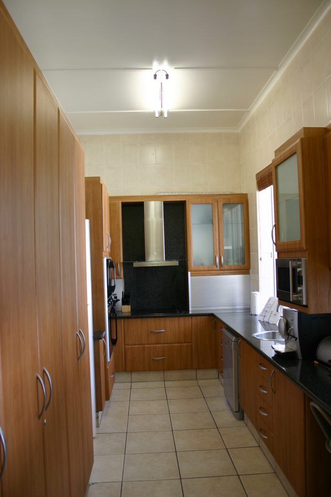 galley kitchen with cherry wrap doors and Rustenberg granite tops