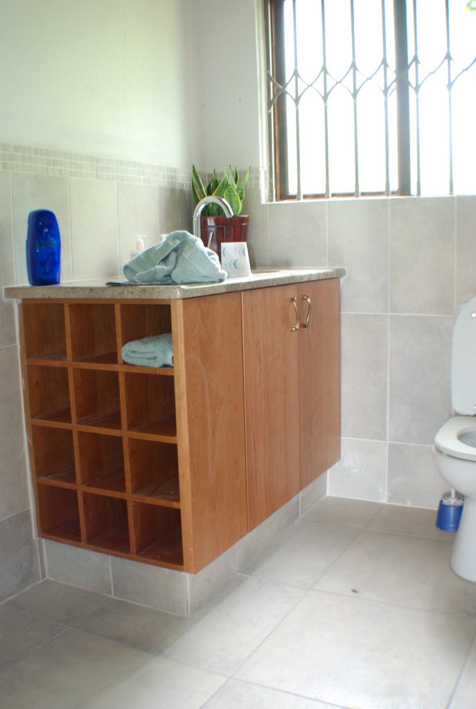 Cherry veneer doors and 'Juperana' granite tops with open towel shelf