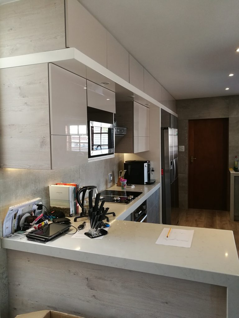 Handleless kitchen in Seno HiGloss Cashmere, Hemlock Nordique Kaindl and London Grey Caesarstone