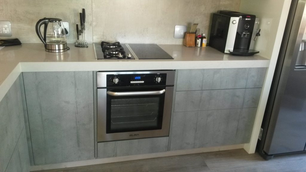 Handleless kitchen in Seno HiGloss Cashmere, Hemlock Nordique Kaindl and London Grey Caesarstone