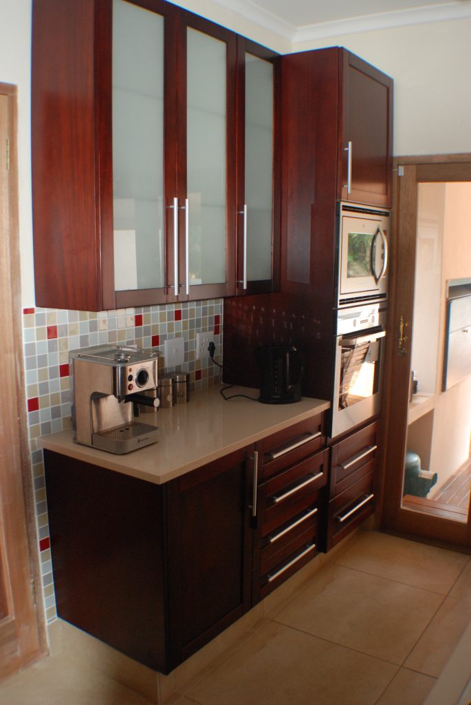 Solid stained mahogany shaker with frosted glass and Sorbet worktops