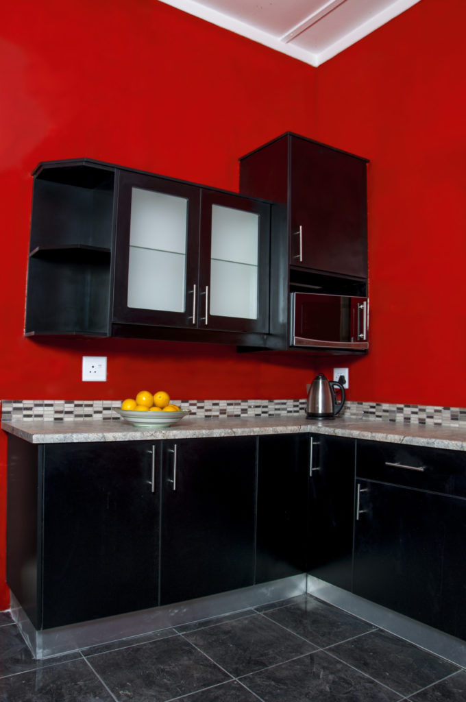 Black Melamine doors with Formica work tops against red walls