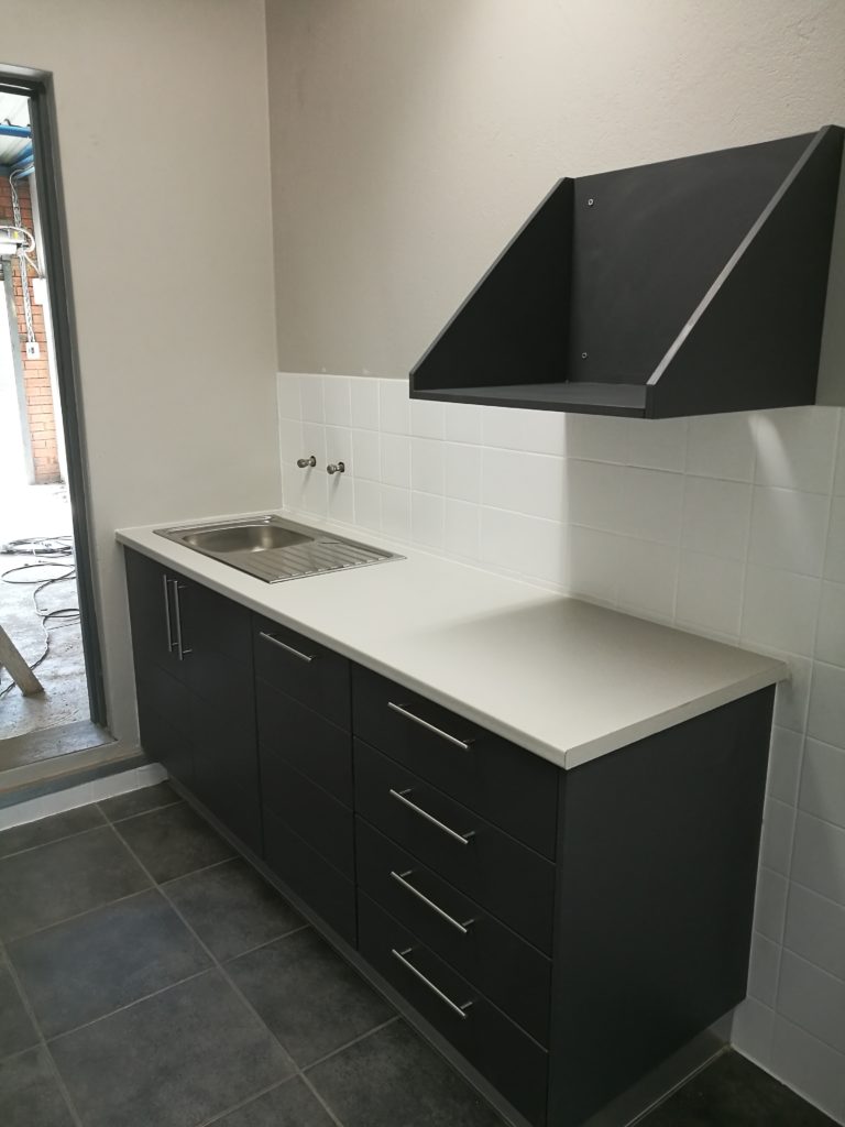 Charcoal wrap with horizontal groove and 'White Myriad' Formica top